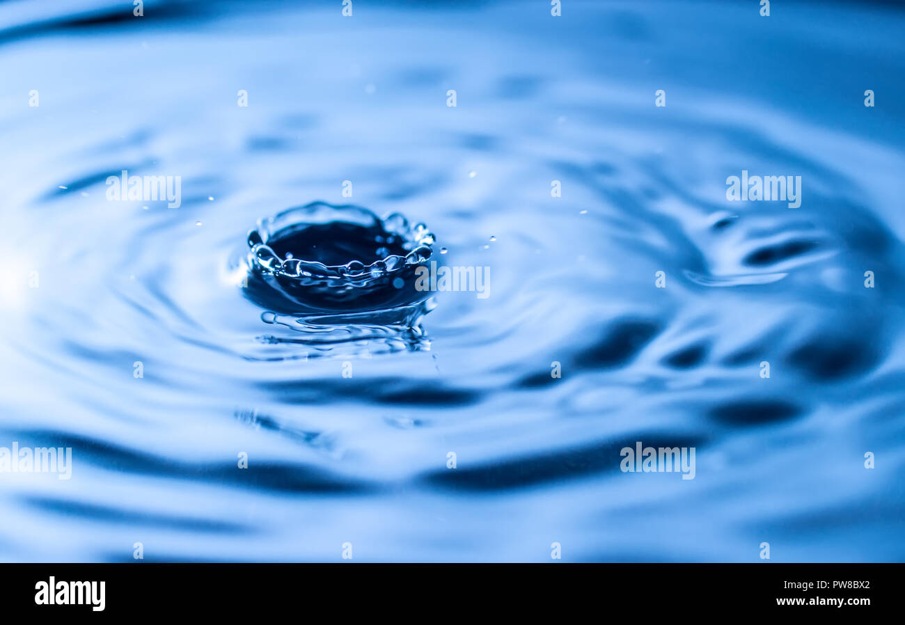Goutte d'eau dans un verre de couleur bleue Banque D'Images