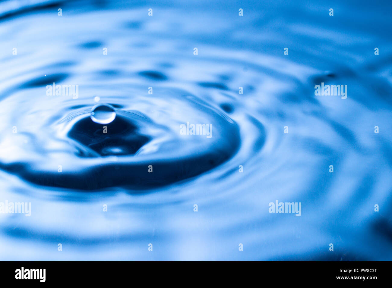 Goutte d'eau dans un verre de couleur bleue Banque D'Images