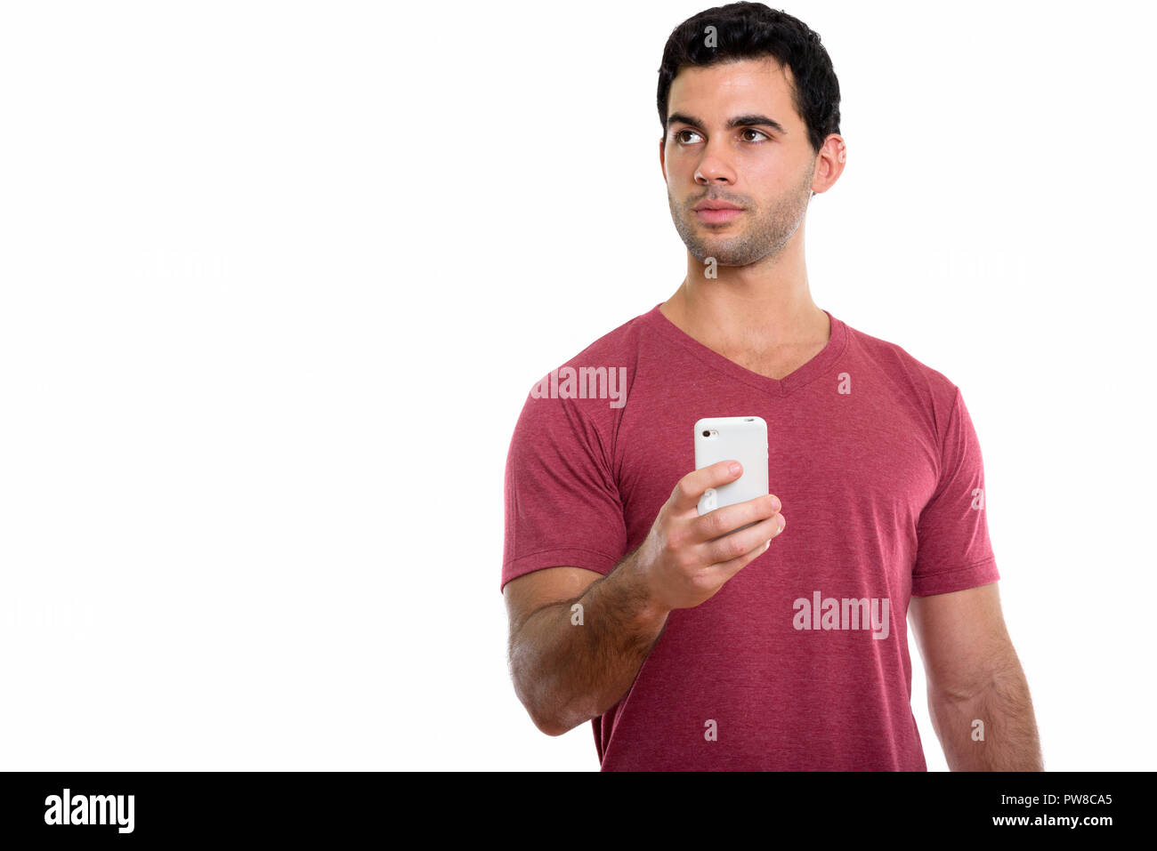 Studio shot of young handsome Young man holding mobile phone Banque D'Images