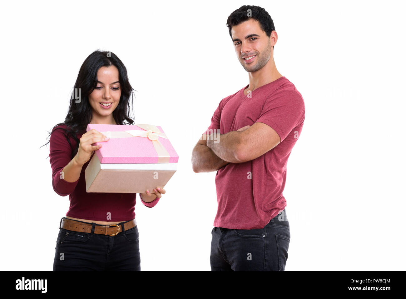 Young happy couple smiling while woman opening gift box et l'homme Banque D'Images