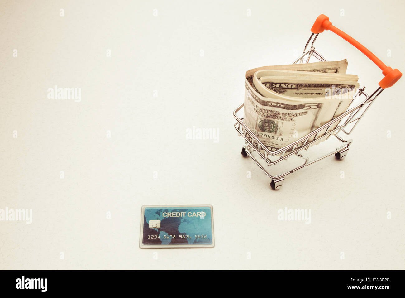 L'argent dans le panier et une carte de crédit sur fond blanc avec l'exemplaire de l'espace. Banque D'Images