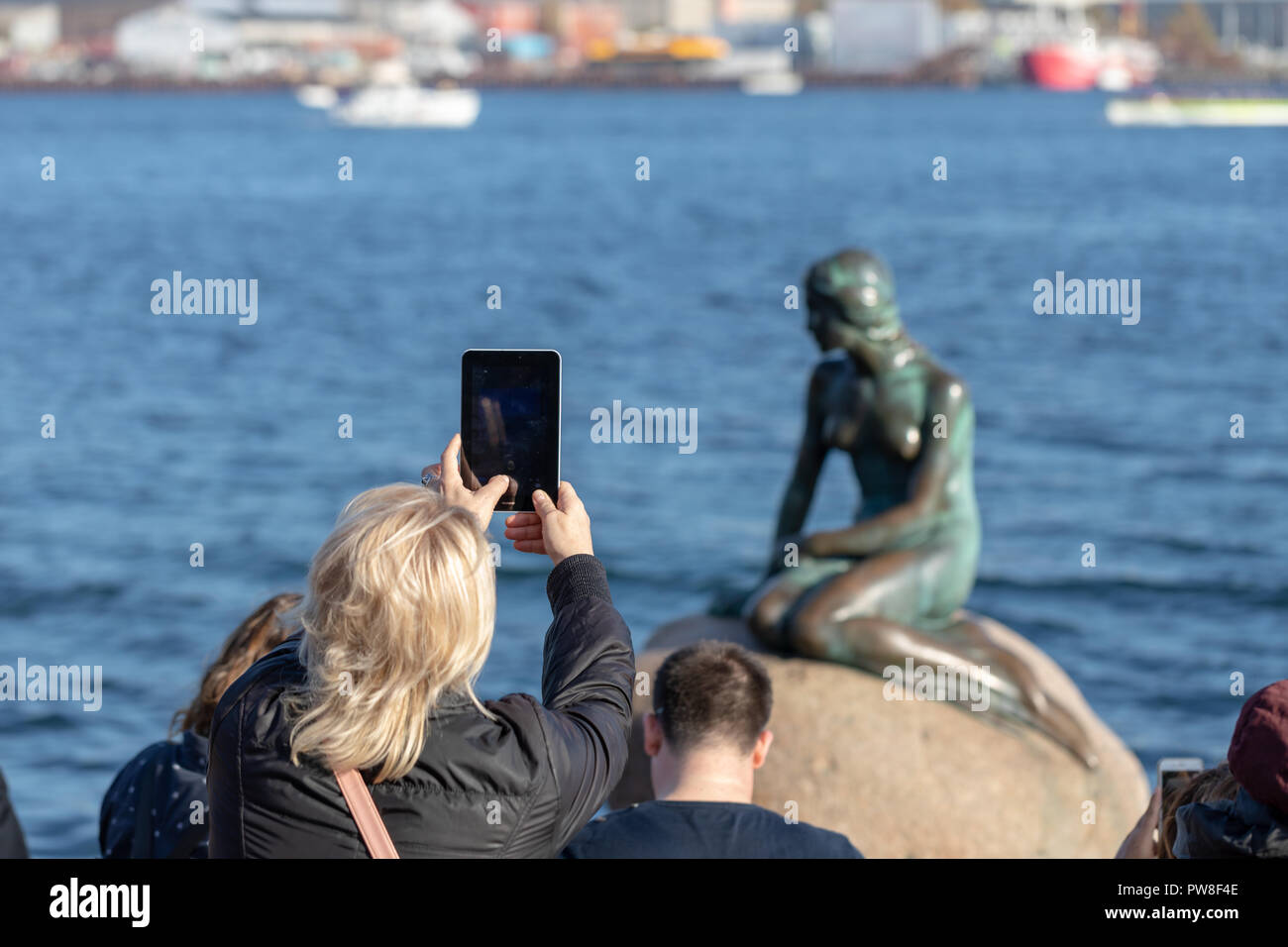 Femme prenant une photo de la Petite Sirène avec un petit comprimé ; Copenhague, Danemark Banque D'Images