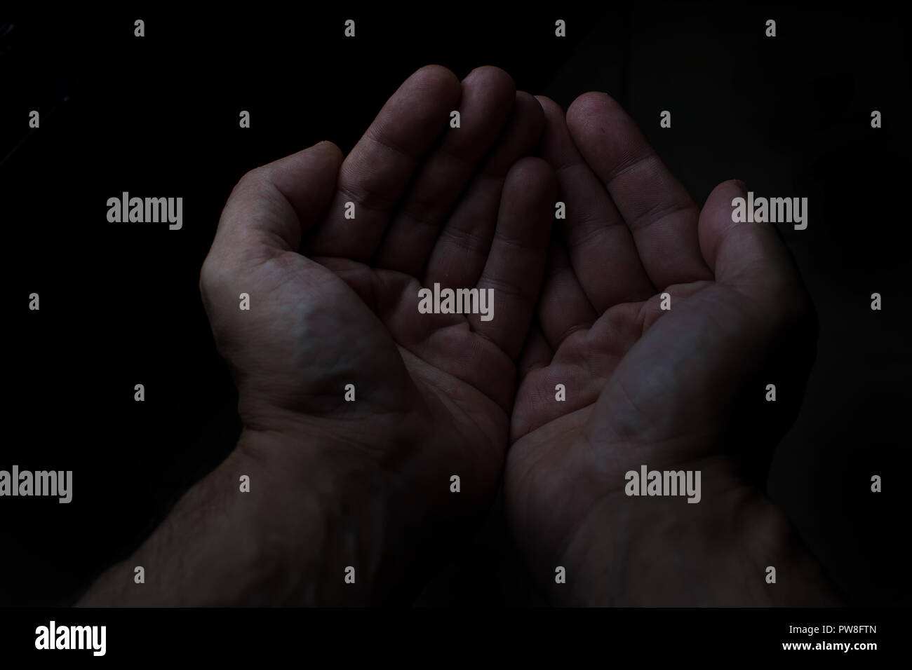 Les deux mains de l'homme dans l'arrière-plan noir Banque D'Images