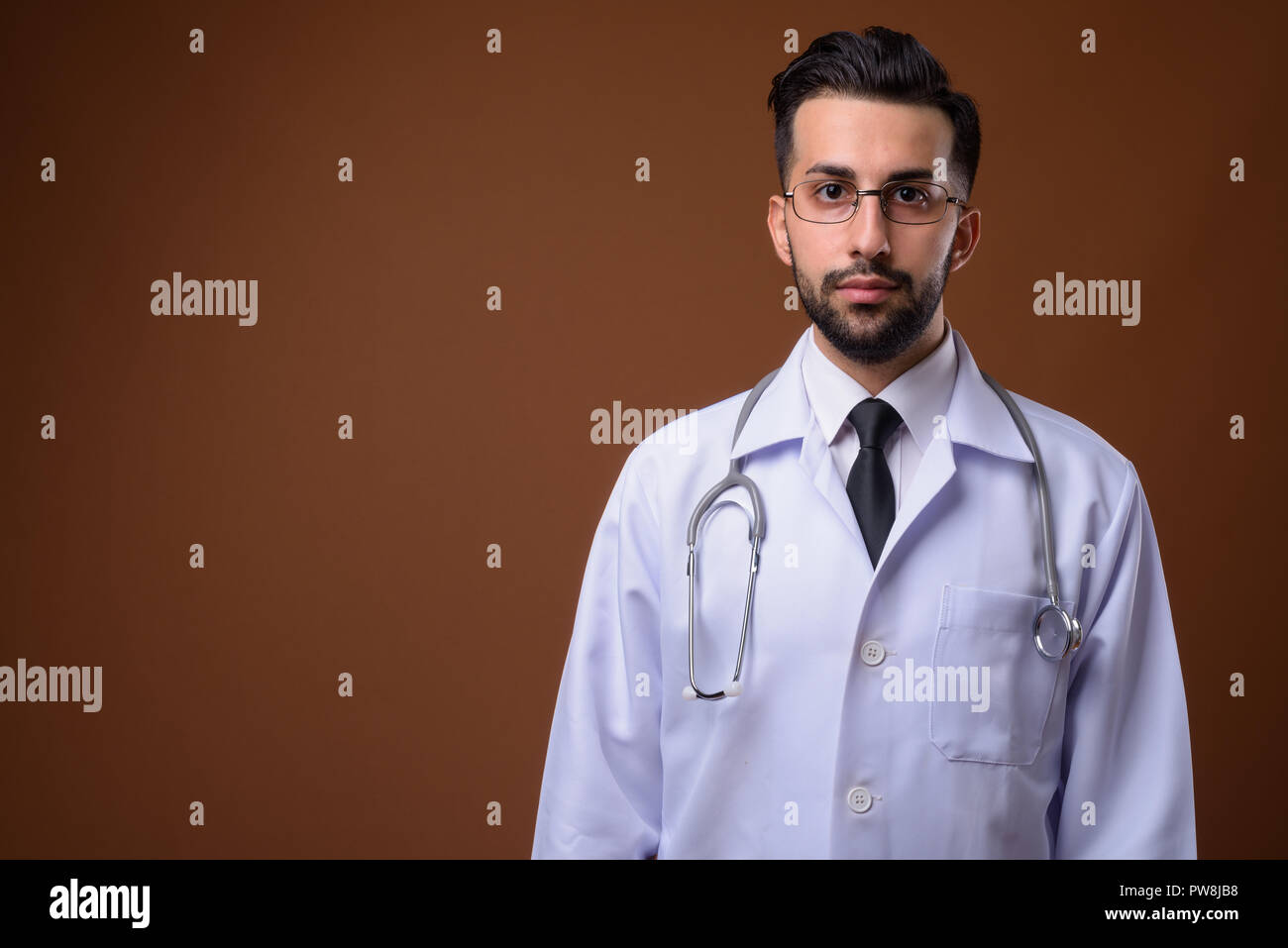 Beau jeune homme barbu médecin iranien contre brown backgrou Banque D'Images