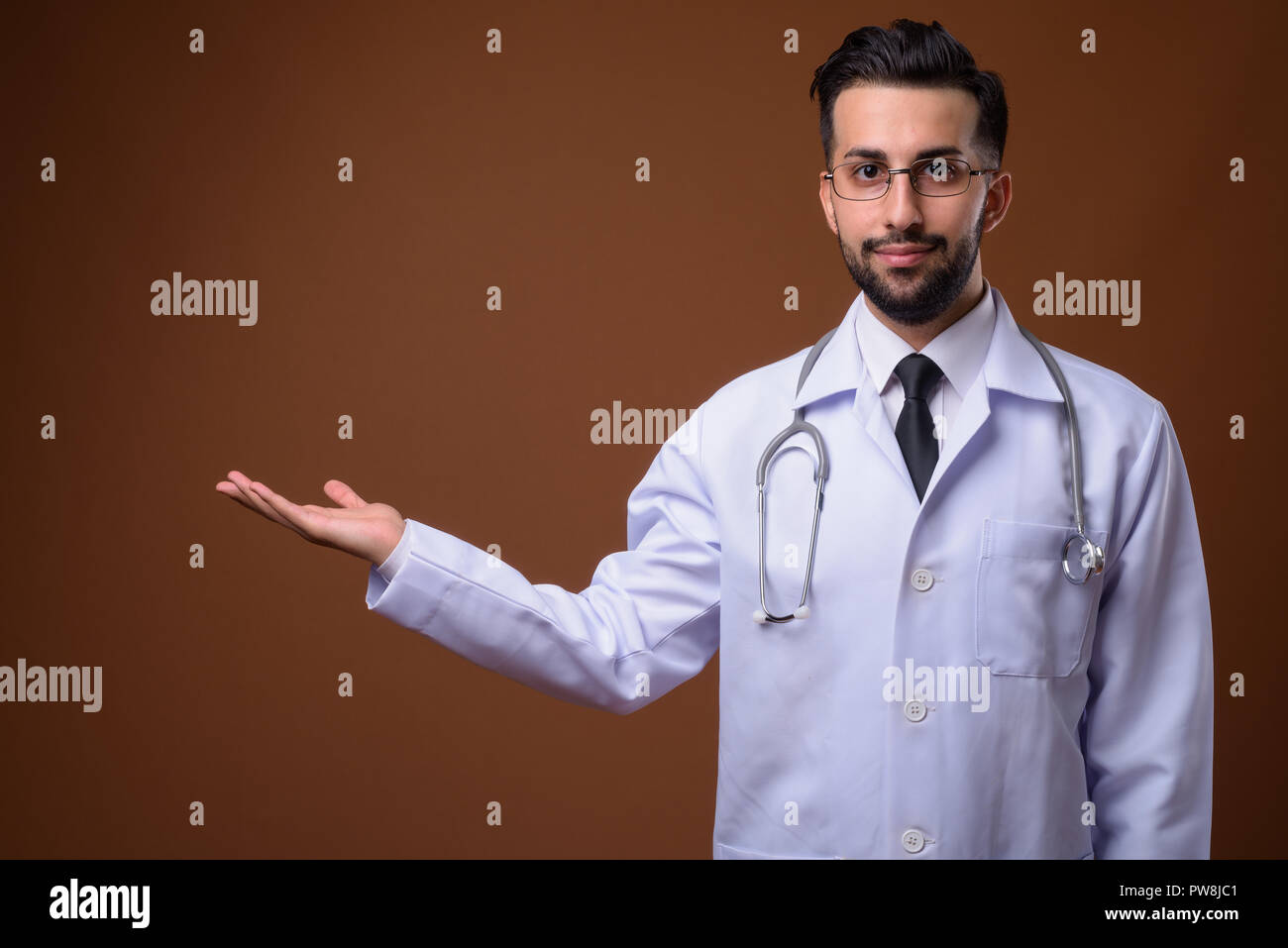 Beau jeune homme barbu médecin iranien contre brown backgrou Banque D'Images