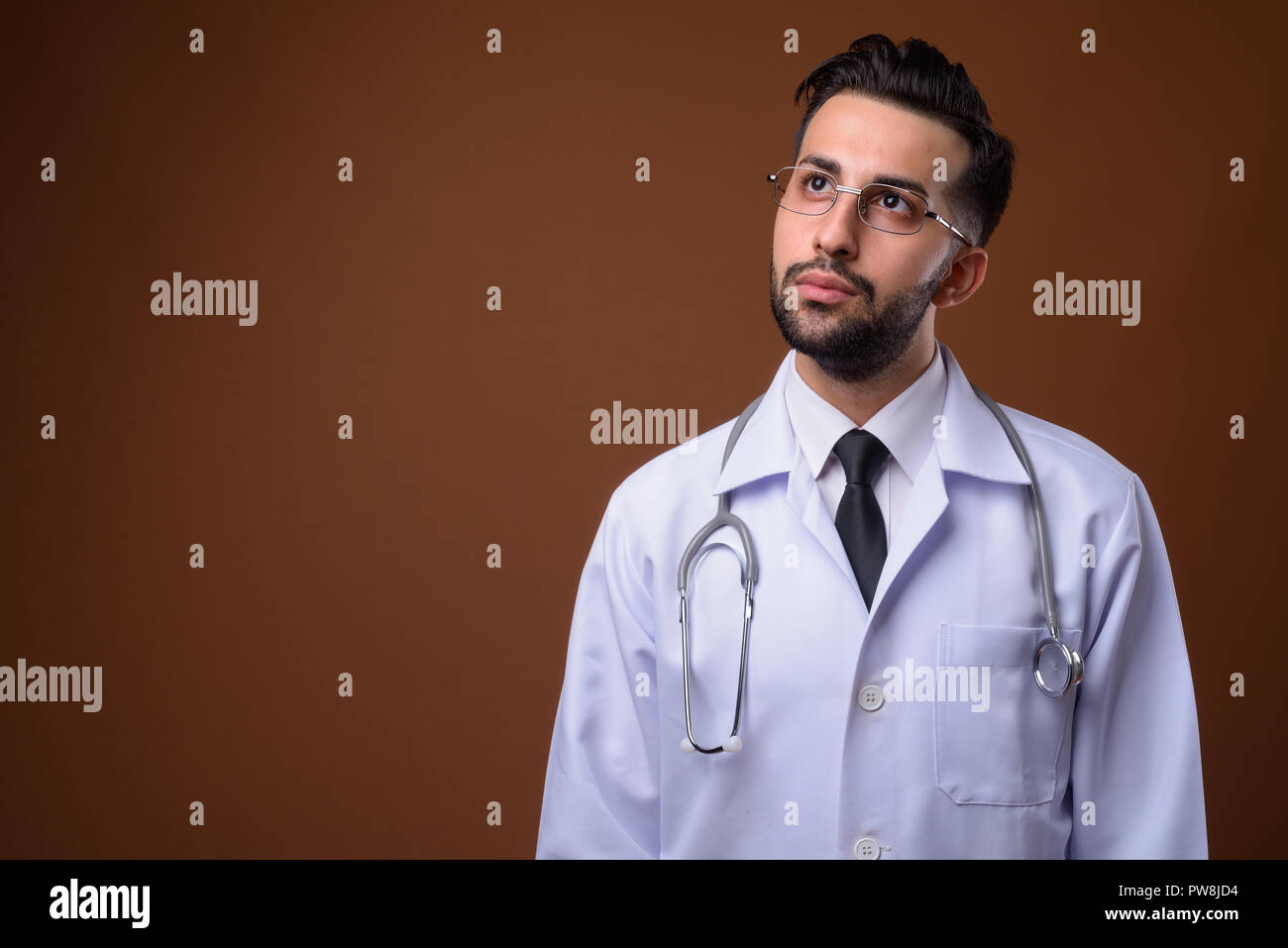 Beau jeune homme barbu médecin iranien contre brown backgrou Banque D'Images