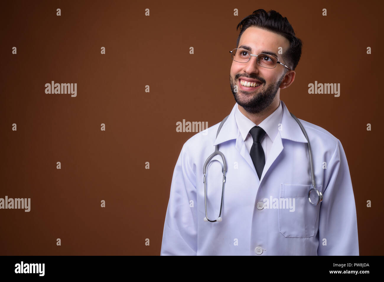 Beau jeune homme barbu médecin iranien contre brown backgrou Banque D'Images