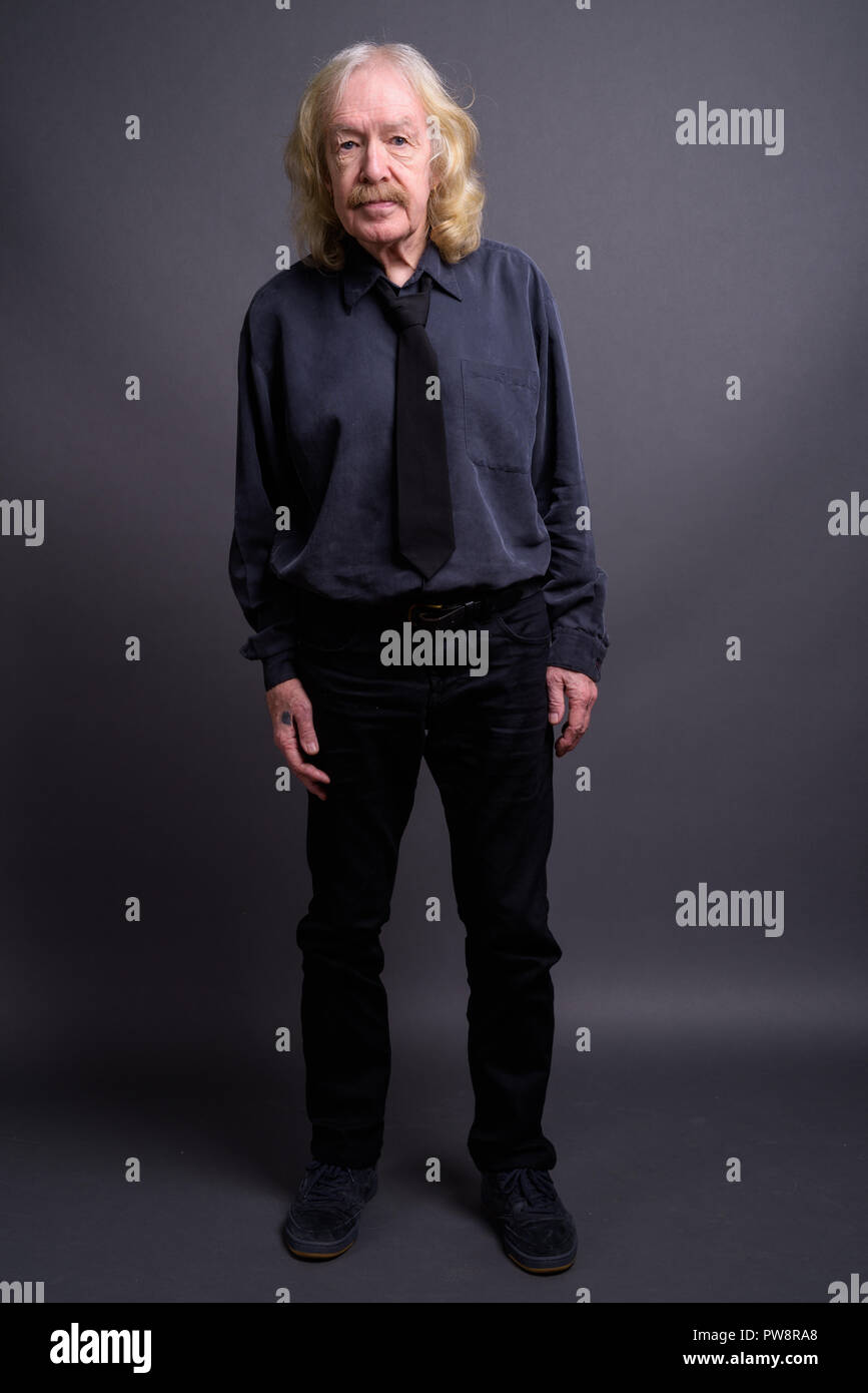 Senior businessman with moustache contre l'arrière-plan gris Banque D'Images