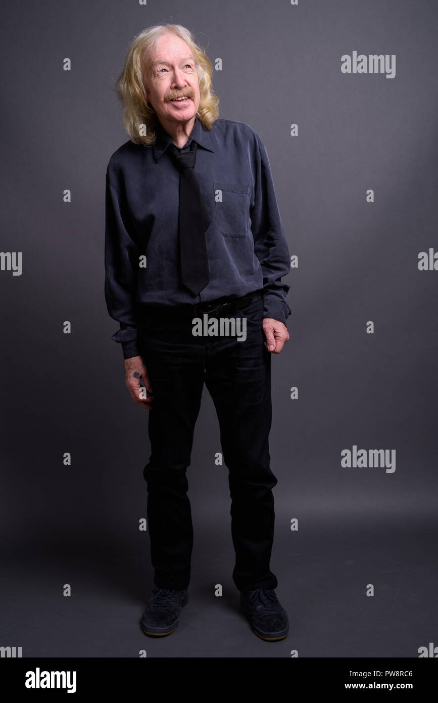 Senior businessman with moustache contre l'arrière-plan gris Banque D'Images