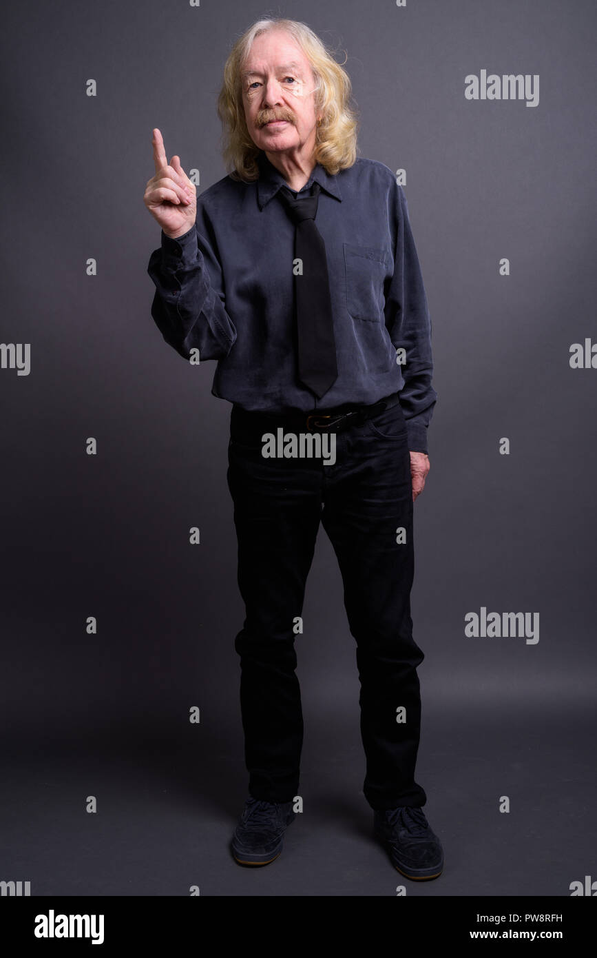 Senior businessman with moustache contre l'arrière-plan gris Banque D'Images