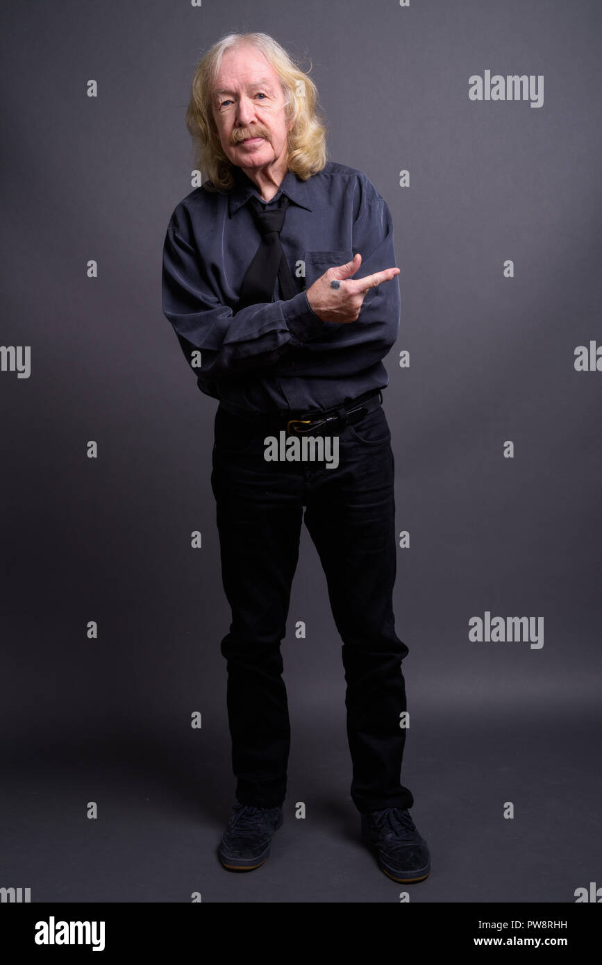 Senior businessman with moustache contre l'arrière-plan gris Banque D'Images