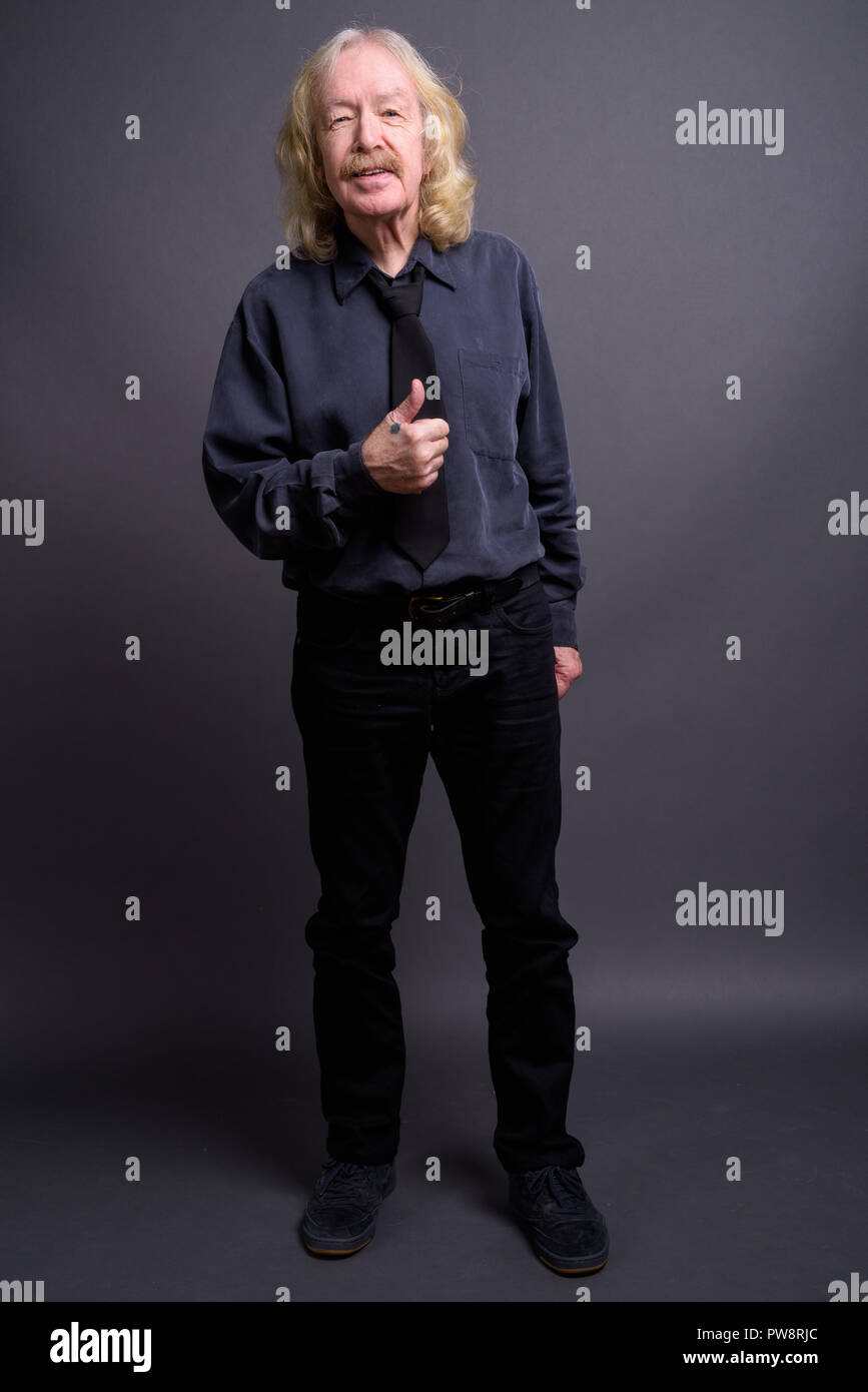 Senior businessman with moustache contre l'arrière-plan gris Banque D'Images