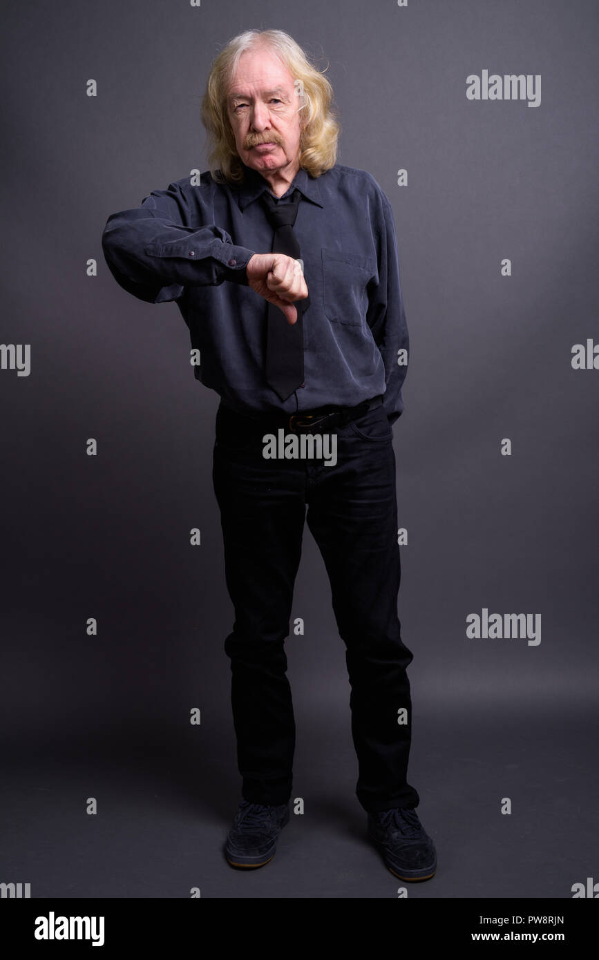 Senior businessman with moustache contre l'arrière-plan gris Banque D'Images