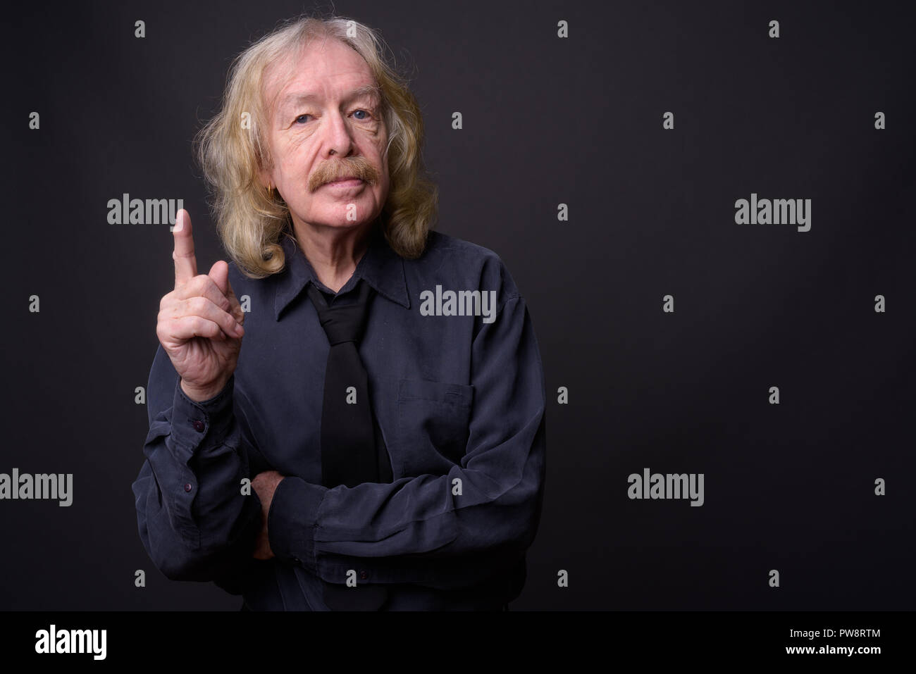 Senior businessman with moustache contre l'arrière-plan gris Banque D'Images