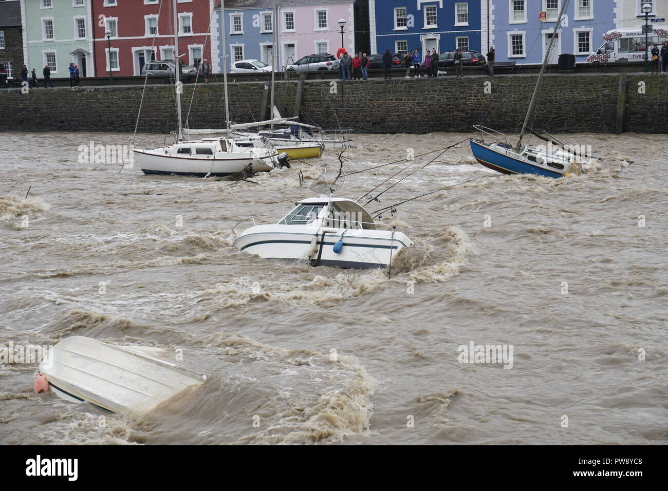 Aberaeron, UK. 13 octobre 2018. Une scène de dévastation à Aberaeron Harbour sur la côte ouest du pays de Galles cet après-midi que de fortes pluies et des vents forts de storm Callum continuent de causer du grabuge. L'eau des crues de la rivière Aeron exerçant son activité sous les arbres et grosses branches tomber sur des bateaux amarrés là dommages à de nombreux et totalement naufrage d'autres. Crédit : Anthony Pugh/Alamy Live News Banque D'Images