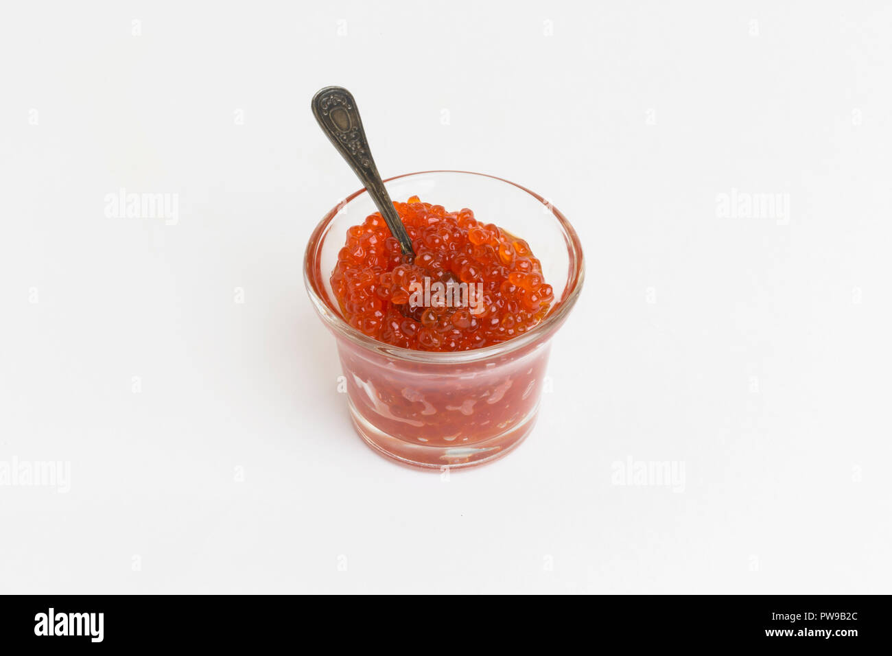 Délicieux de luxe. Caviar rouge en verre avec cuillère sur fond blanc Banque D'Images