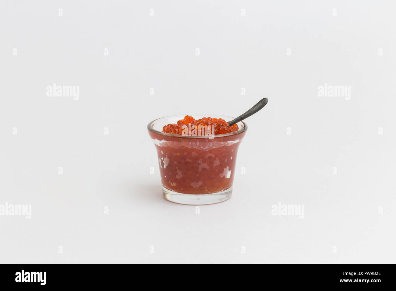 Délicieux de luxe. Caviar rouge en verre avec cuillère sur fond blanc Banque D'Images