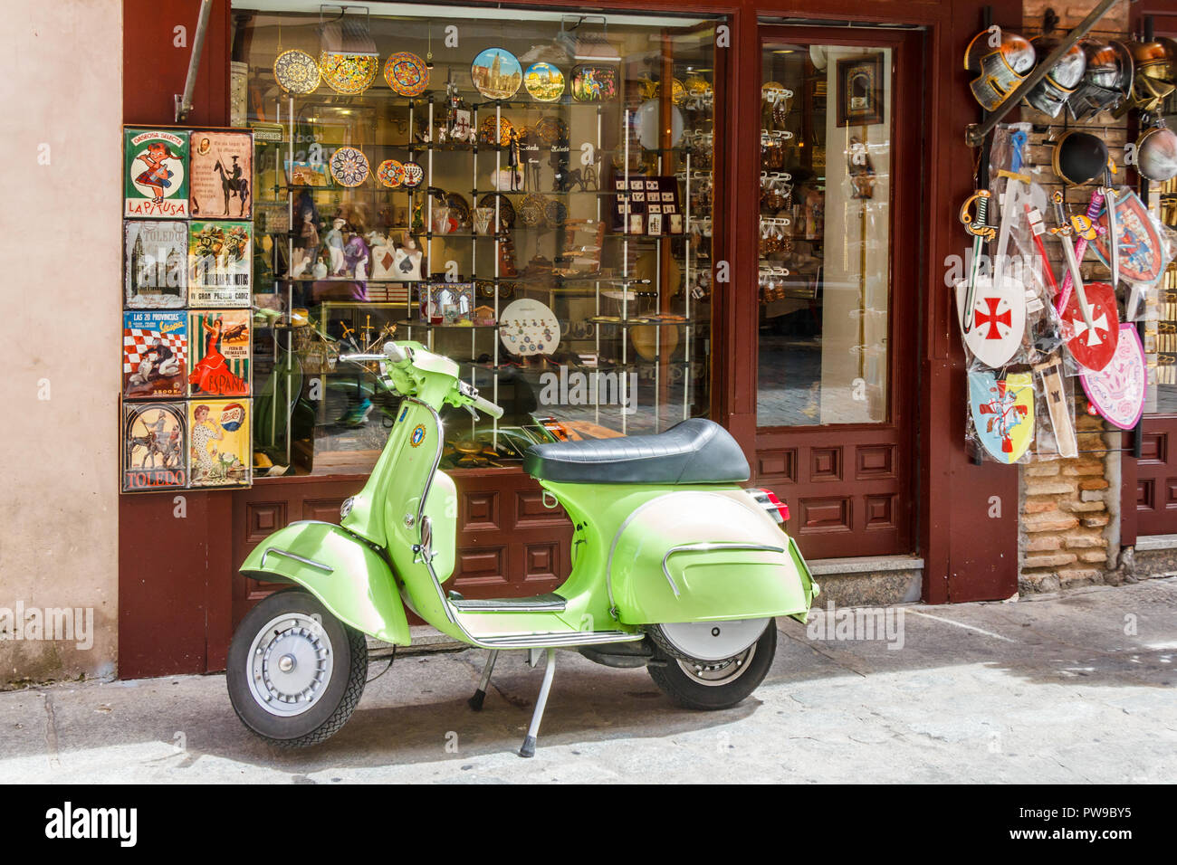 Toledo, Espagne - 6 juin 2018 : : Lime Green scooter garé à l'extérieur de magasin de souvenirs. La trottinette est idéale pour circuler dans les rues étroites. Banque D'Images