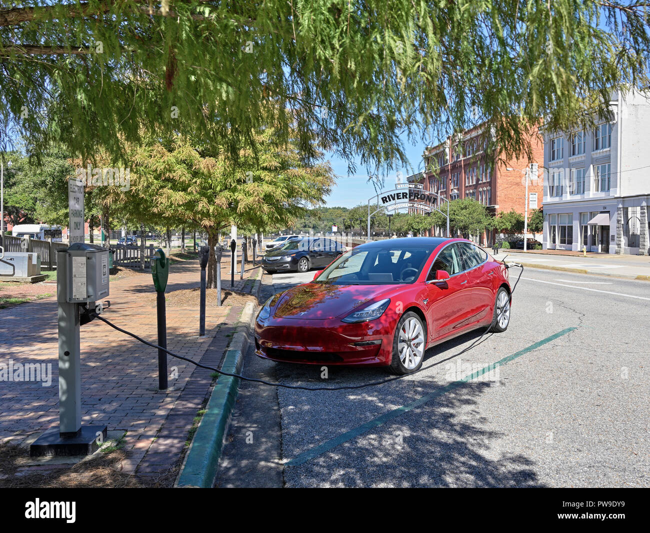 Tesla rouge Modèle 3 (3), garé et de charge à un véhicule électrique ou de la station de charge de voiture électrique sur la rue à Montgomery, en Alabama, USA. Banque D'Images