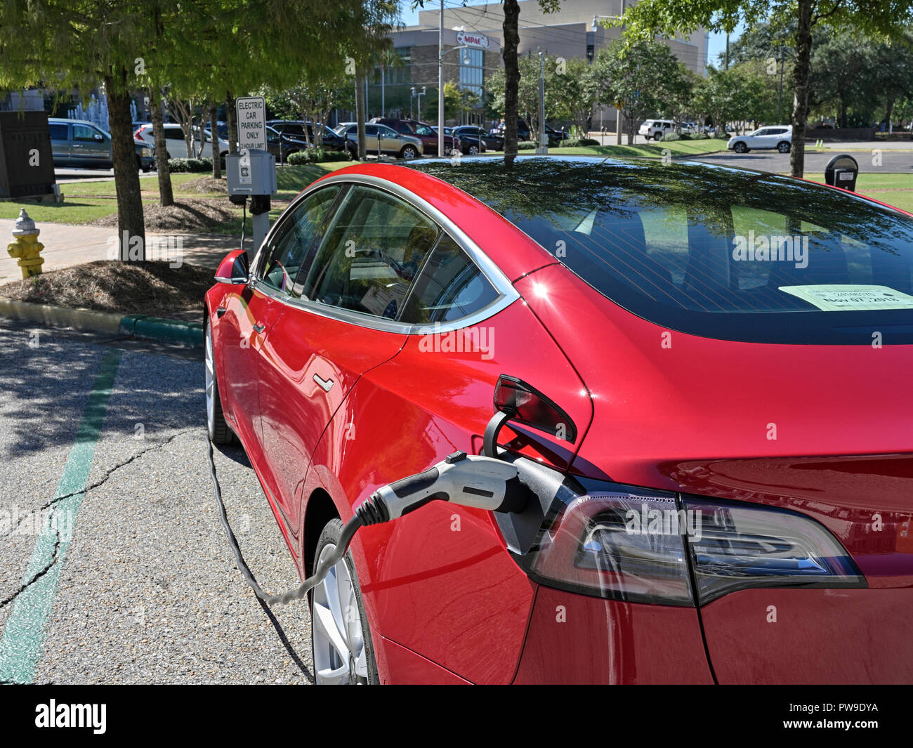 Tesla rouge Modèle 3 (3), garé et de charge à un véhicule électrique ou de la station de charge de voiture électrique sur la rue à Montgomery, en Alabama, USA. Banque D'Images