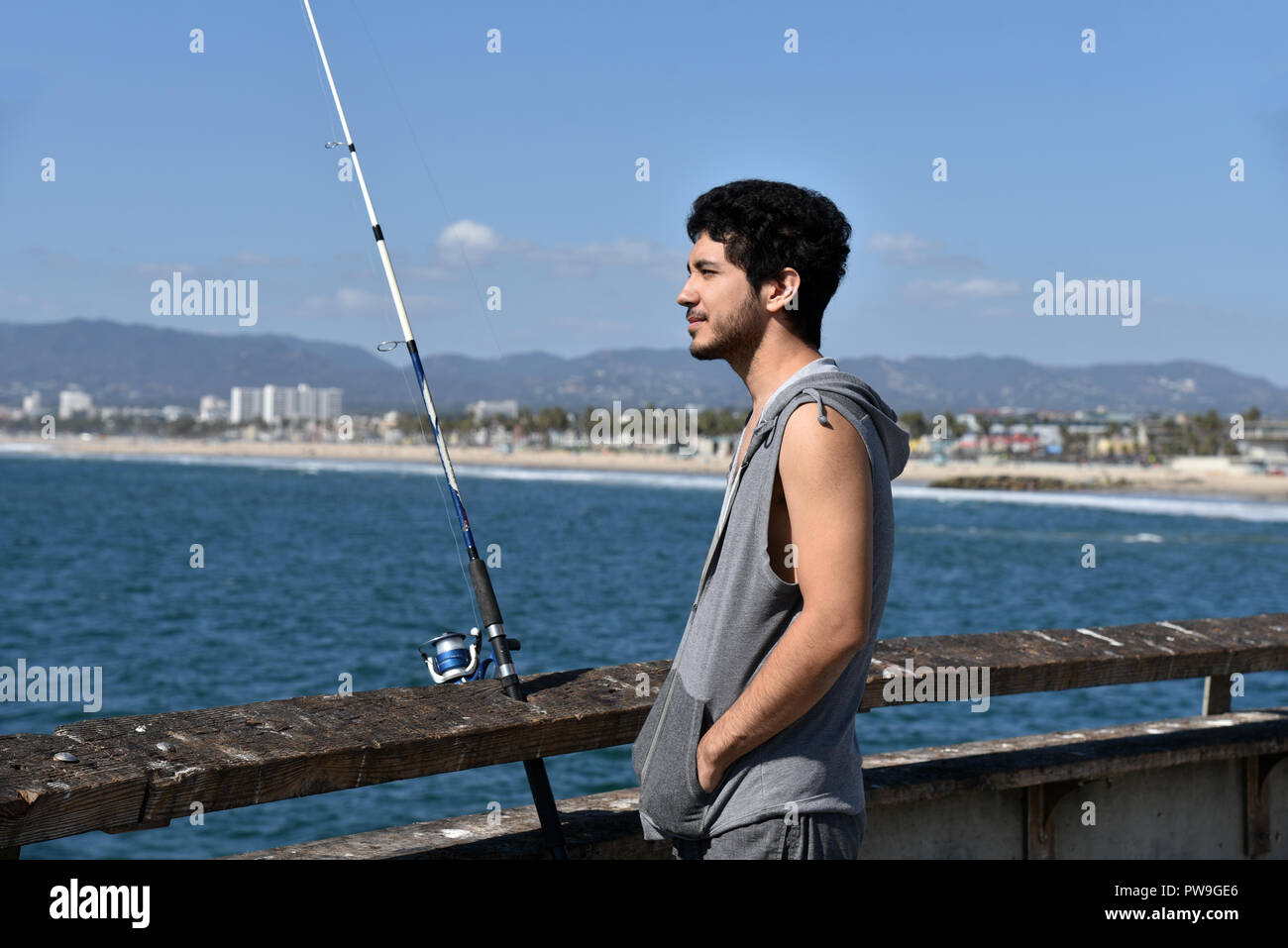 Bel homme multi-ethnique sur un quai de pêche dans un lieu tropical un jour d'été Banque D'Images