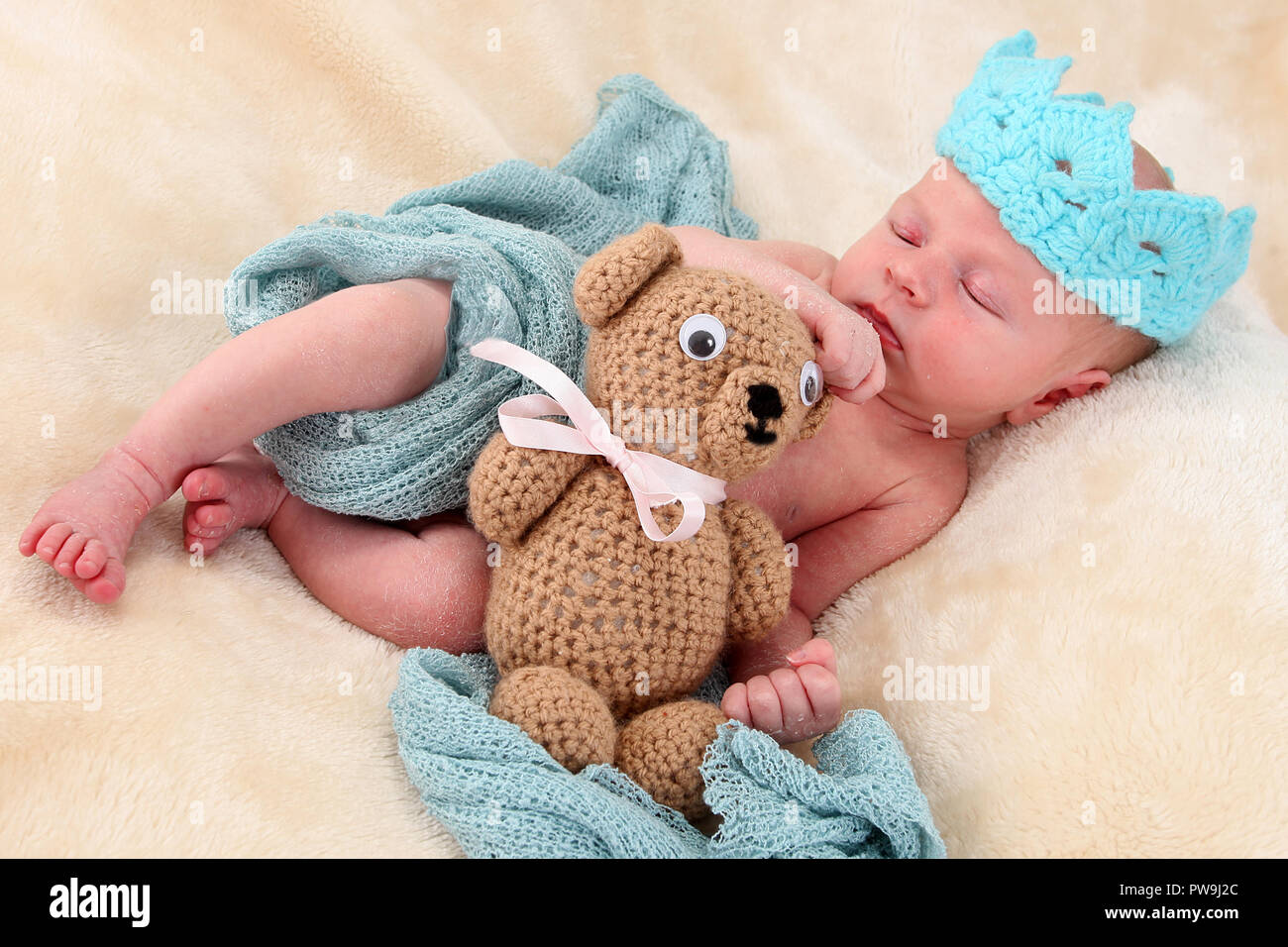 nouveau-né bébé garçon endormi sur une couverture qui câlin un teddy Banque D'Images