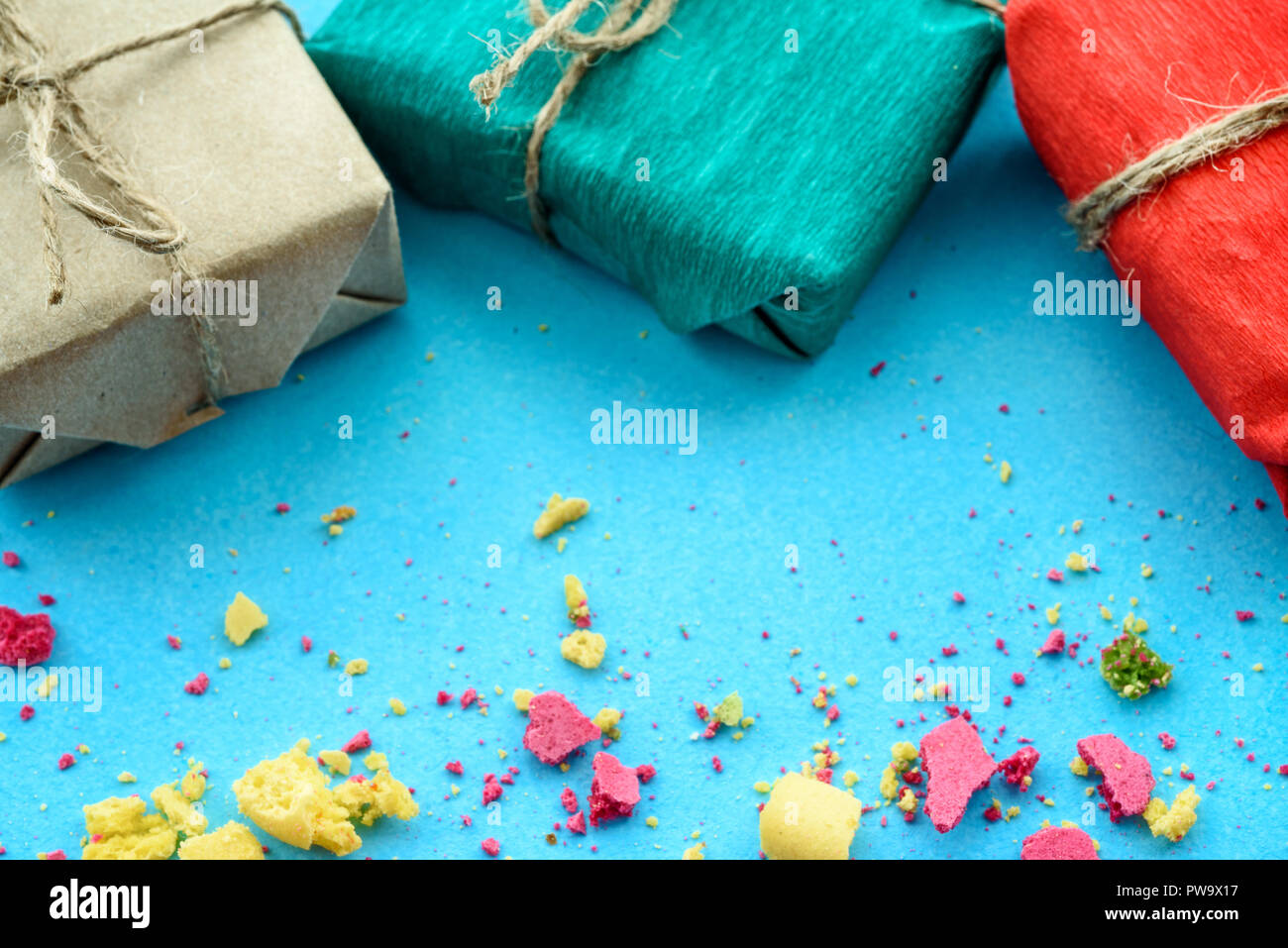 Fond bleu avec des dons et des miettes d'un gâteau multicolore, vue du dessus Banque D'Images