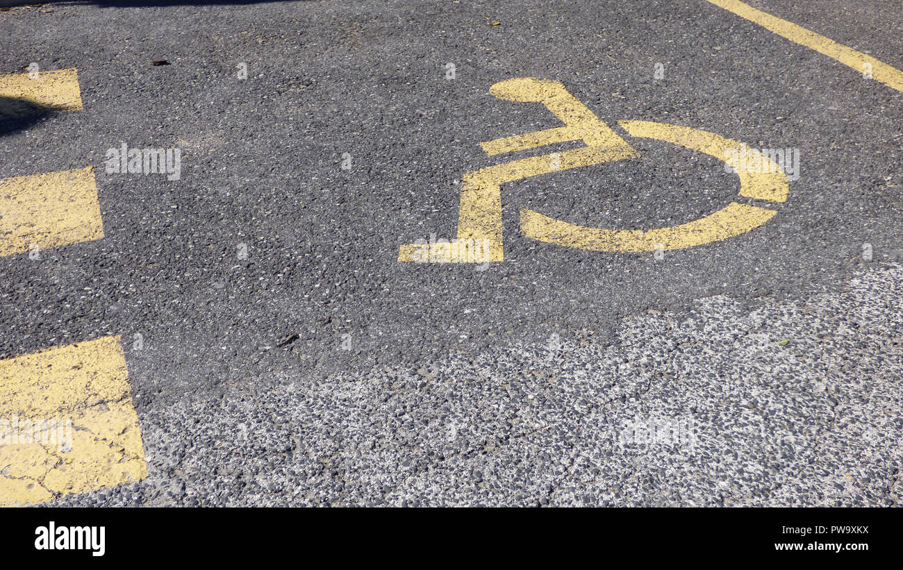 Parking Handicap jaune symbole Icône peinte à l'Asphalte Banque D'Images