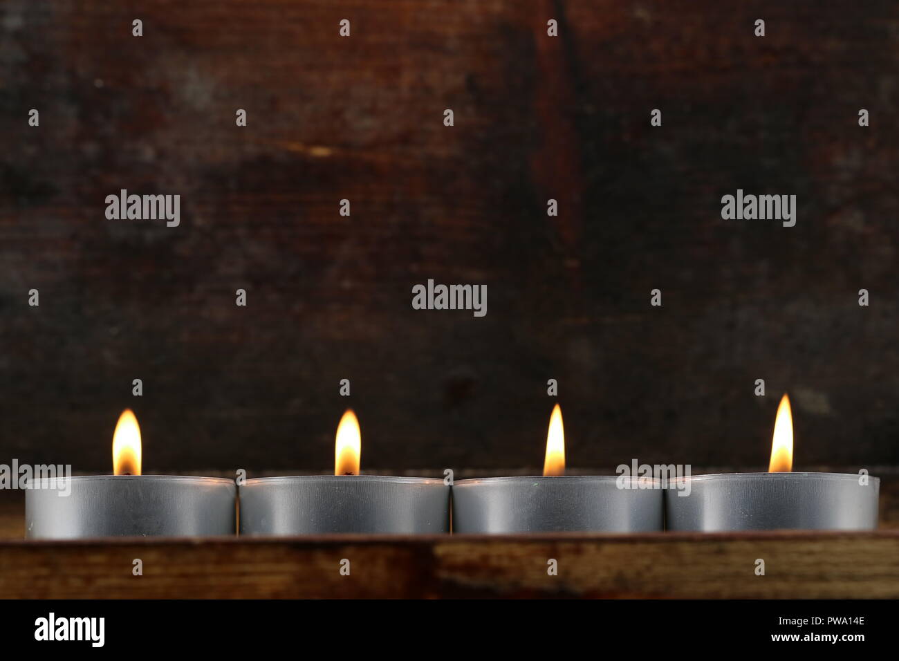 Quatre bougies, bougies sur fond de bois foncé Banque D'Images