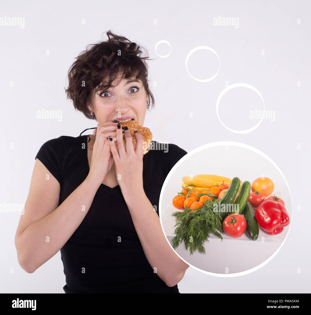 Jeune fille avec de gros burger sur fond blanc de penser à fruits et légumes Banque D'Images