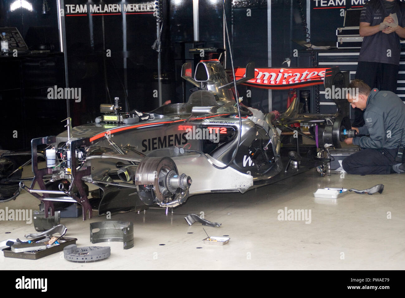 F1 mécanique à travailler sur une Mercedes McLaren F1 race car dans la voie des stands de Silverstone l'atelier Banque D'Images