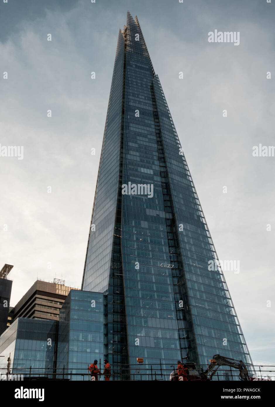 Le Shard, le plus haut bâtiment de l'Europe de l'Ouest, à l'allure d'un tesson de verre, avec les travailleurs de la construction au bas premier plan. copie espace, portrait. Banque D'Images