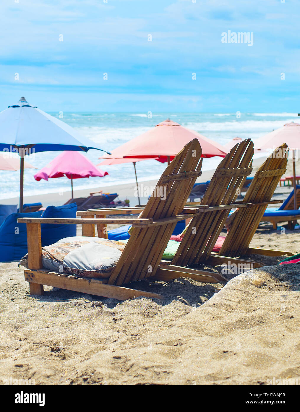 Des chaises, des sacs et des parasols sur la plage. L'île de Bali, Indonésie Banque D'Images