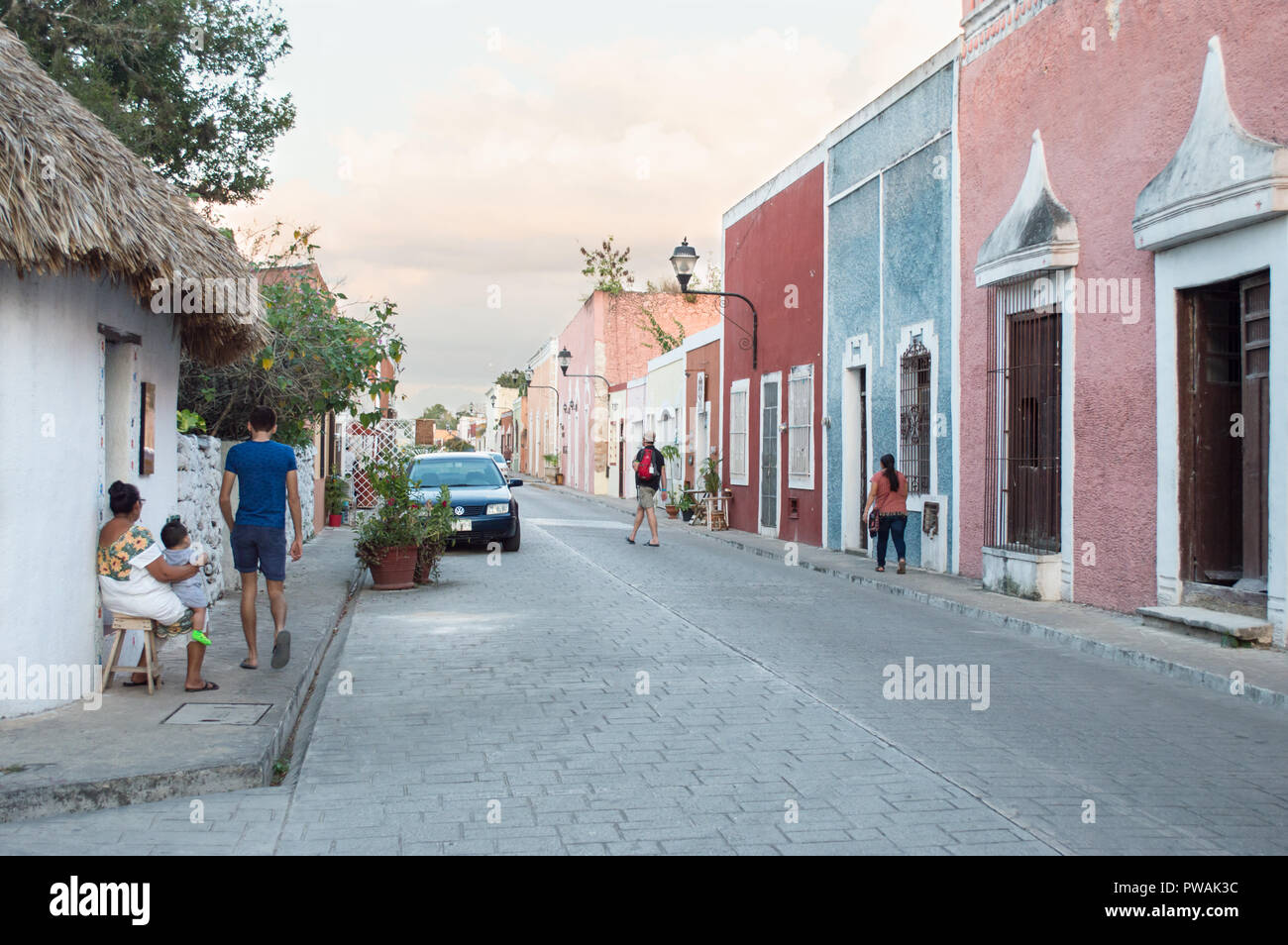 La rue de Valladolid, Yucatan. Dame maya avec bébé et les touristes en marchant. Banque D'Images