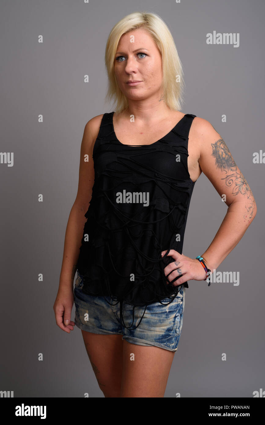 Portrait de femme aux cheveux blonds contre l'arrière-plan gris Banque D'Images