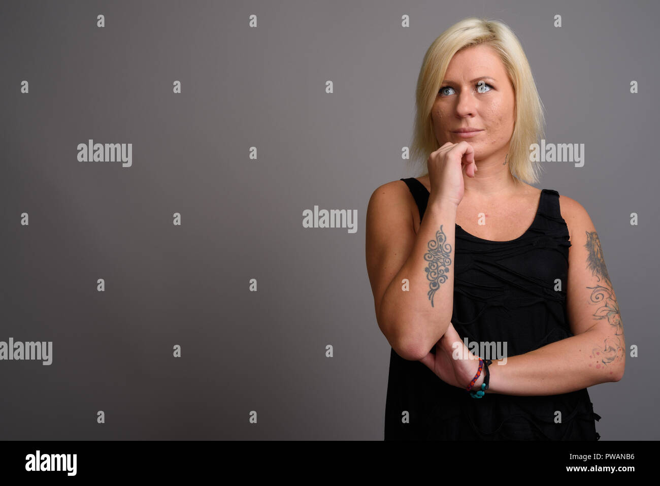 Portrait de femme aux cheveux blonds contre l'arrière-plan gris Banque D'Images