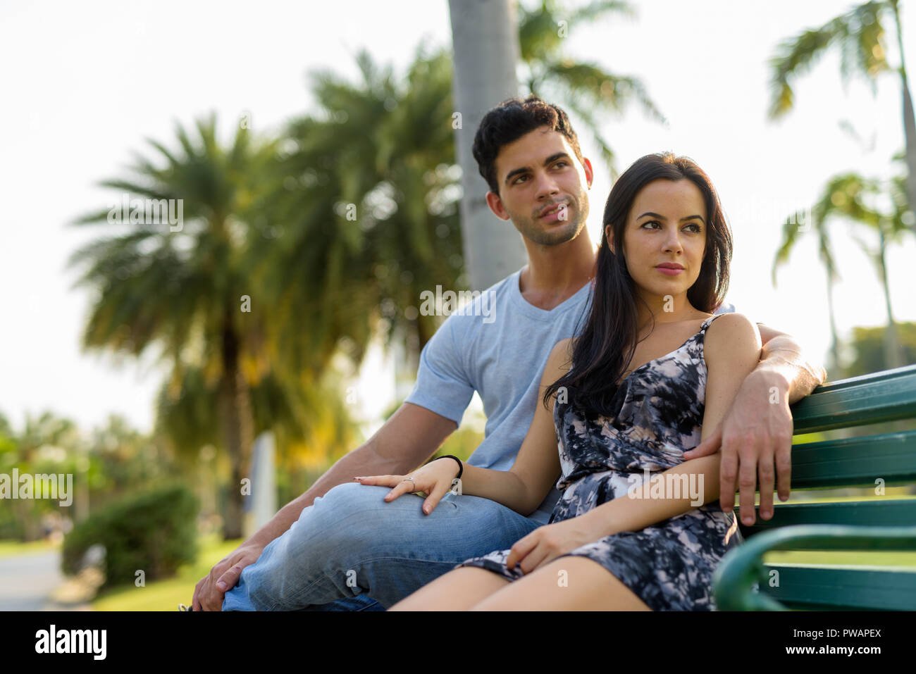 Young Hispanic couple relaxing in the park ensemble Banque D'Images