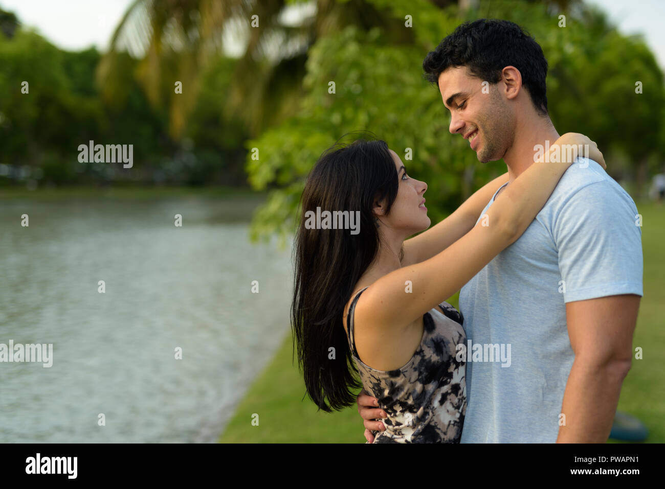 Young Hispanic couple relaxing in the park ensemble Banque D'Images