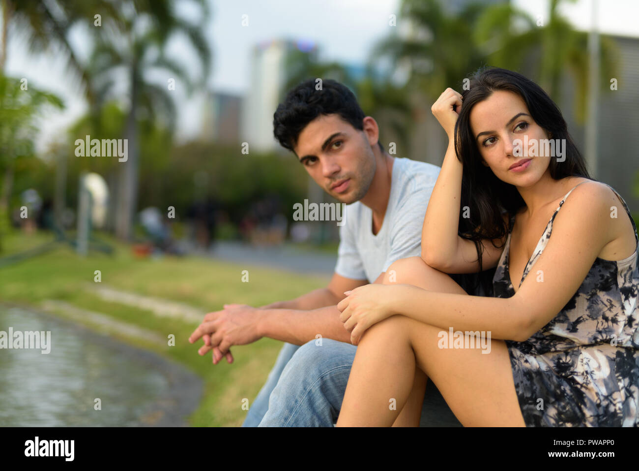 Young Hispanic couple relaxing in the park ensemble Banque D'Images
