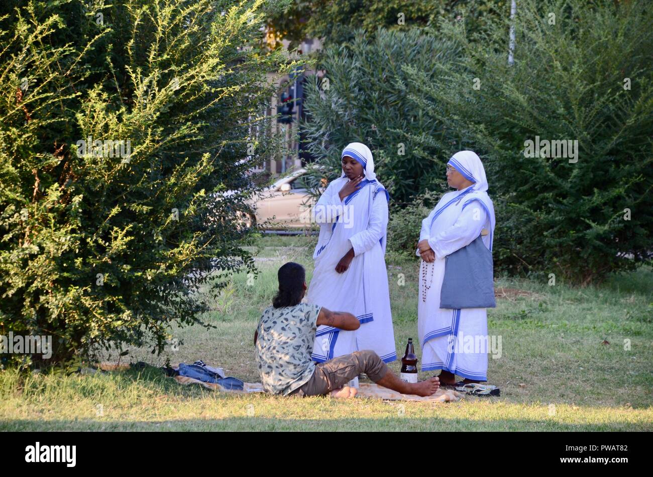 Deux religieuses de la congrégation des Missionnaires de la Charité à Tirana Albanie parler à un sans-abri dans un parc Banque D'Images