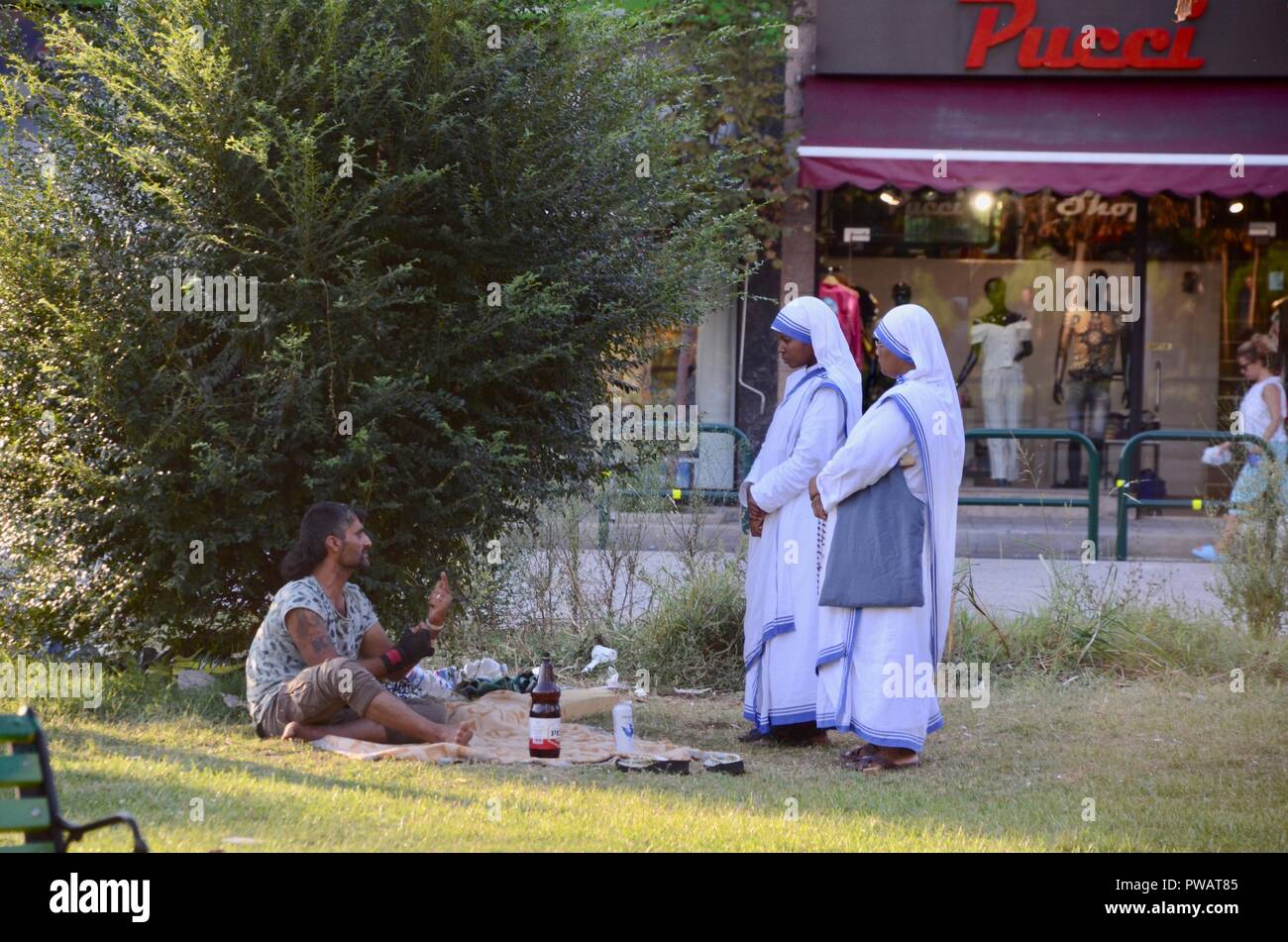 Deux religieuses de la congrégation des Missionnaires de la Charité à Tirana Albanie parler à un sans-abri dans un parc Banque D'Images