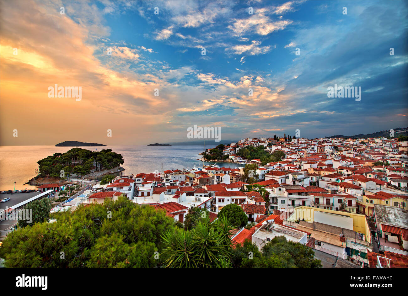 Vue de la ville de Skiathos autour du soleil depuis la tour de l'horloge de l'église d'Agios Nikolaos. L'île de Skiathos, Sporades du Nord, Magnessia, Thessalie, Grèce. Banque D'Images