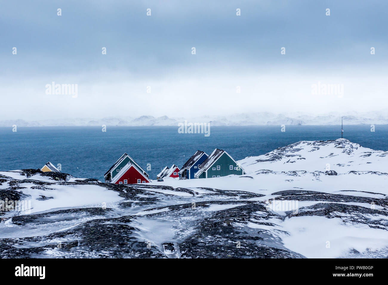 Rangées de maisons colorées des inuits se cachant dans les rochers avec fjord en arrière-plan, banlieue de la capitale de l'Arctique Nuuk, Groenland Banque D'Images