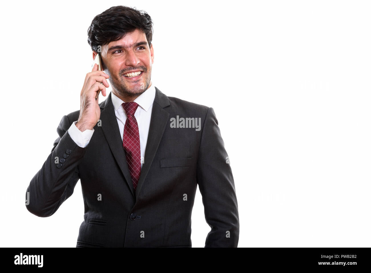 Les jeunes professionnels Persian businessman smiling while talking on mobile Banque D'Images