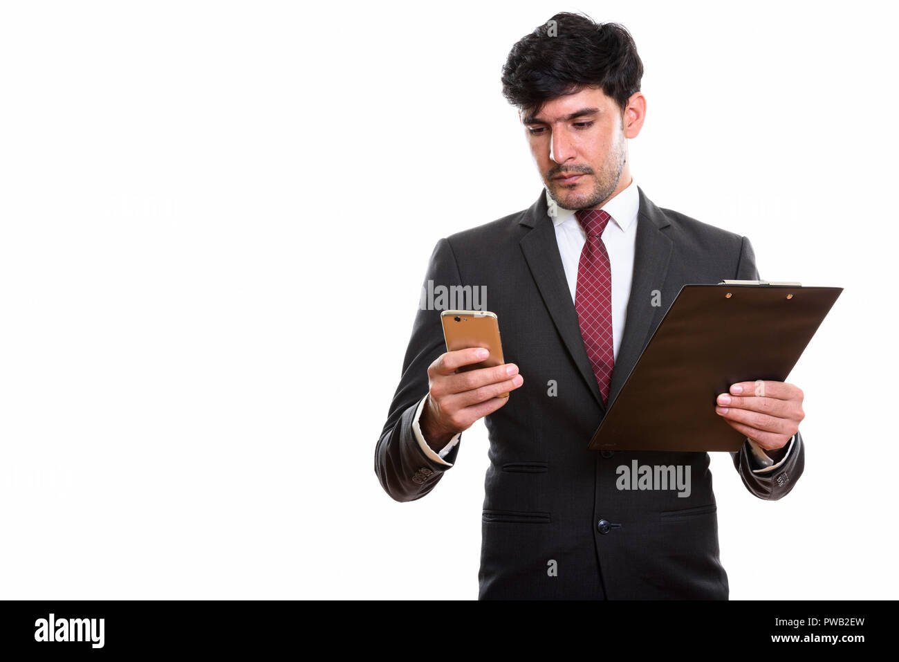 Studio shot of young businessman holding clipboard tout en Perse Banque D'Images