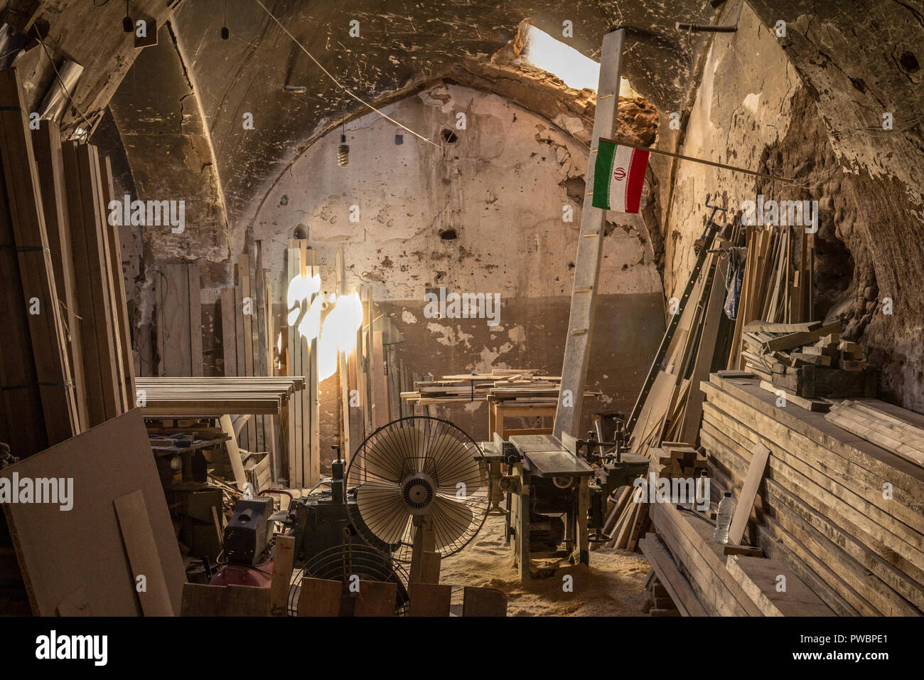 Atelier de charpentier vu dans la ville de Yazd, Iran, avec un drapeau iranien. Planches et typique des instruments de travail du bois peut être vu tout autour de l'atelier Banque D'Images