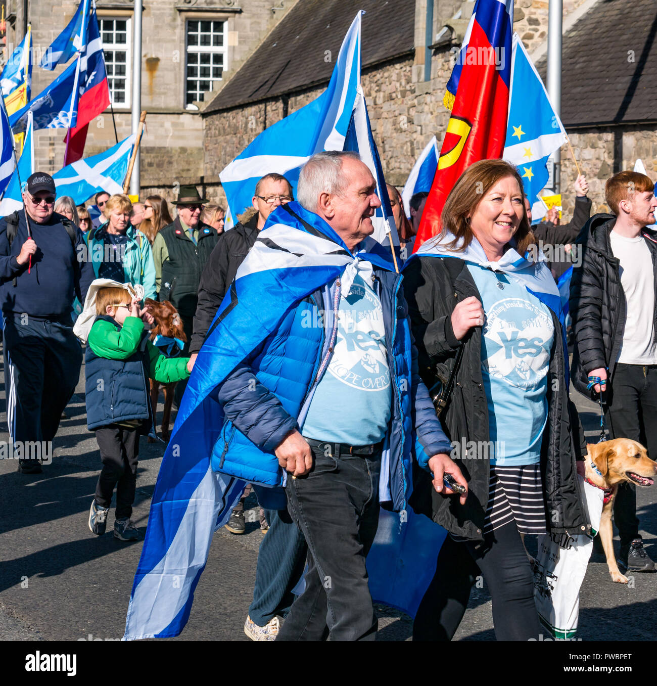 Les gens drapés dans des drapeaux nationaux marchant à tous sous une même bannière AUOB mars 2018 l'indépendance de l'Ecosse, Royal Mile, Édimbourg, Écosse, Royaume-Uni Banque D'Images