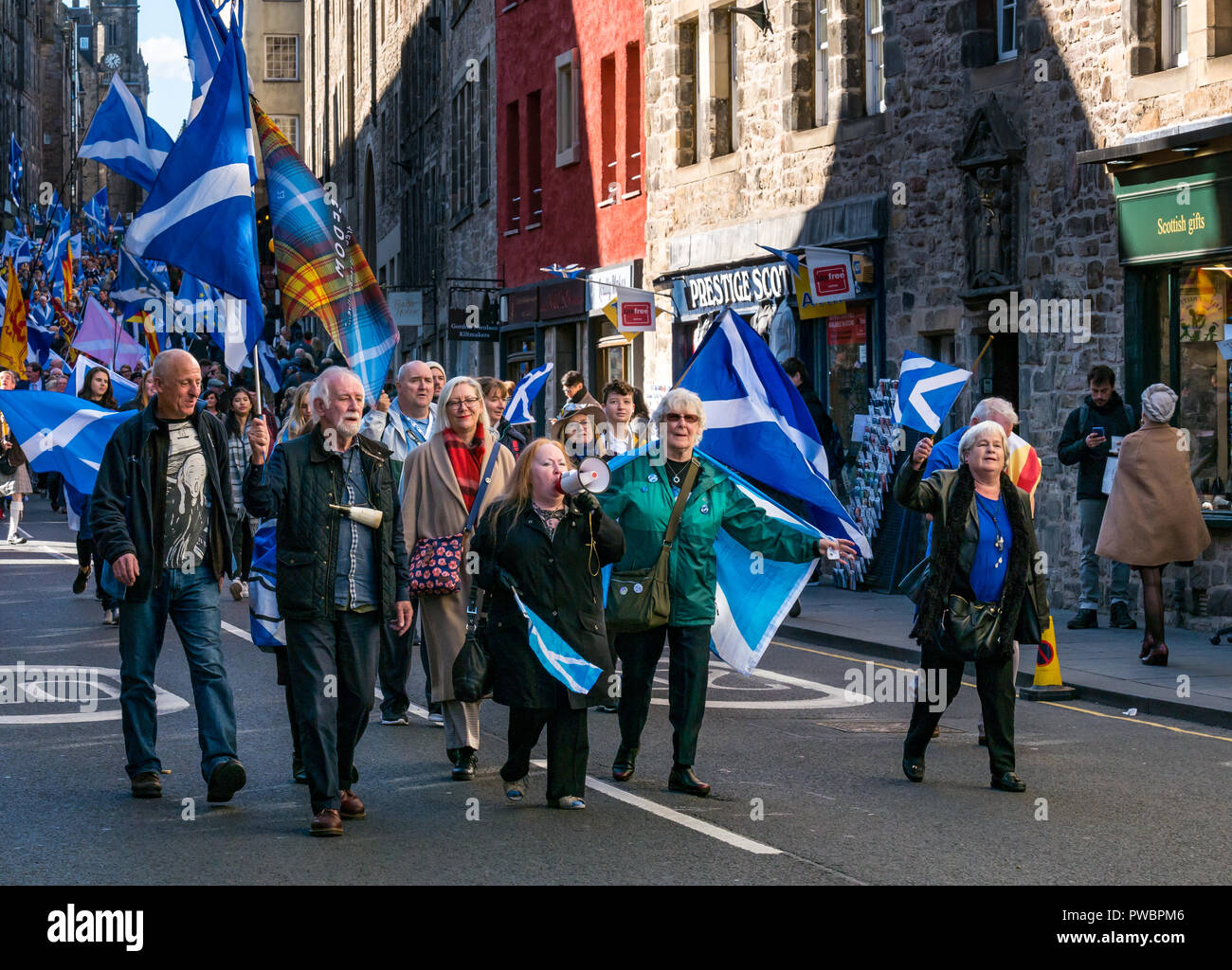 Gens portant des drapeaux nationaux marcher du tout sous une même bannière AUOB mars 2018 l'indépendance de l'Ecosse, Royal Mile, Édimbourg, Écosse, Royaume-Uni Banque D'Images