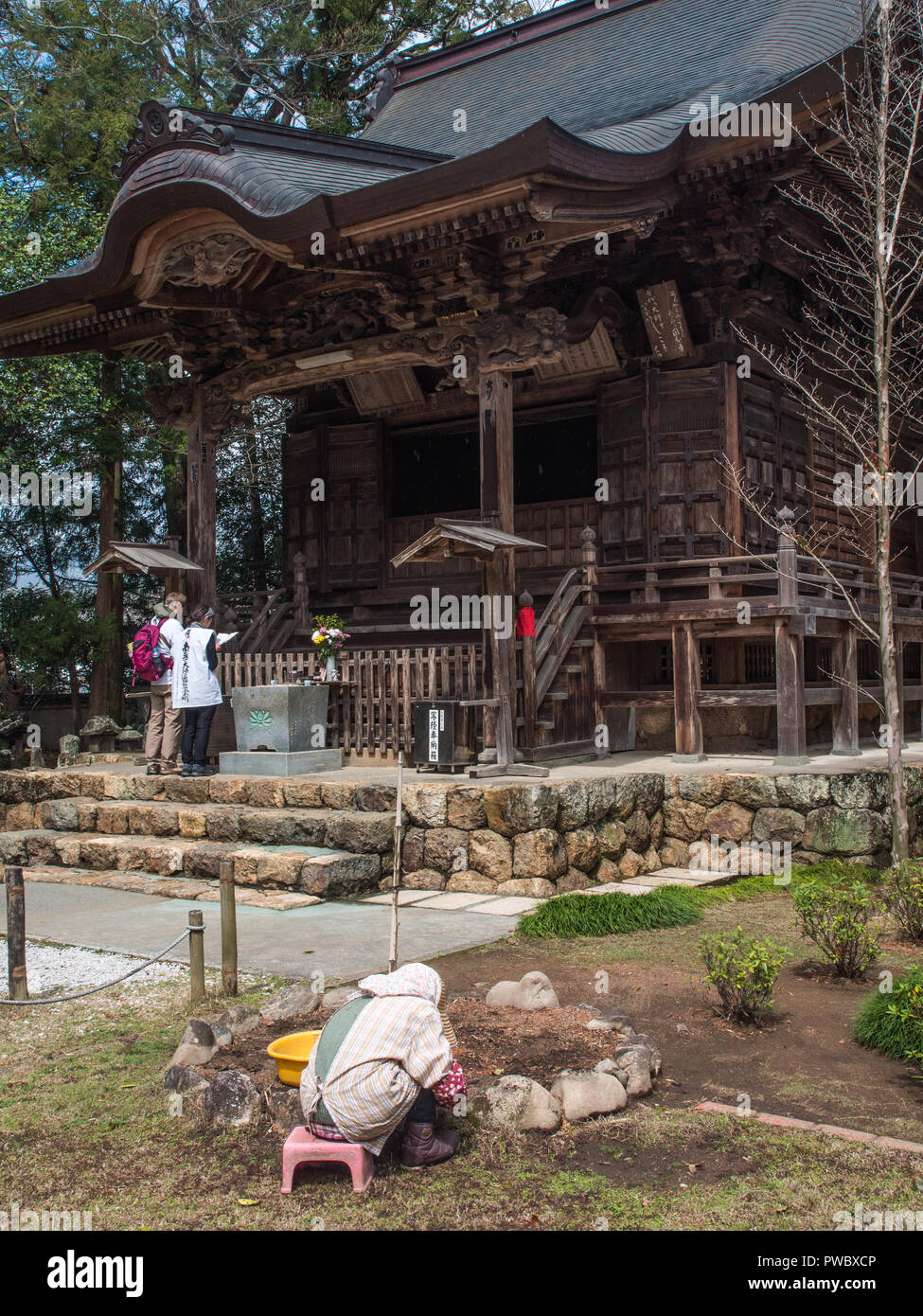 Henro pèlerins récitant des prières, une femme jardinage, Kokubunji temple 29 temple 88, Shikoku, pèlerinage, Kochi, Japon Banque D'Images