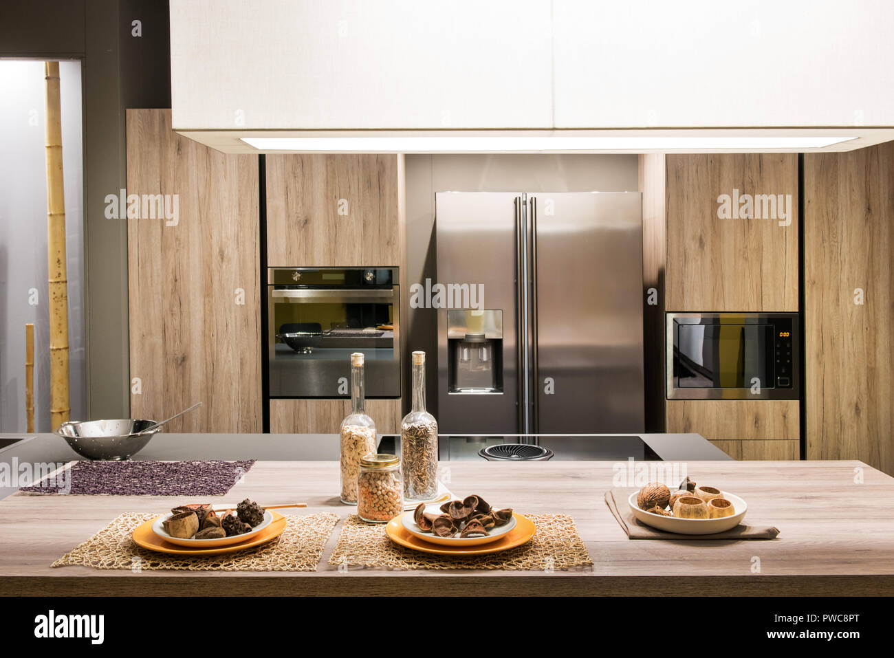 Cuisine équipée moderne avec intérieur en bois et les appareils et plaques de biscuits fraîchement cuits au four sur un centre de table Banque D'Images